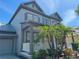 Two-story home with a covered porch featuring columns and lush landscaping in a tropical style at 625 Mirabay Blvd, Apollo Beach, FL 33572