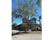 Charming two-story home with a metal roof, a well-manicured lawn, and mature landscaping at 625 Mirabay Blvd, Apollo Beach, FL 33572