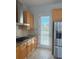 Well-lit kitchen complete with stainless steel appliances, wooden cabinetry, and access to the backyard at 625 Mirabay Blvd, Apollo Beach, FL 33572
