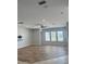 Open living room with wood-look flooring, ceiling fan, and ample natural light at 625 Mirabay Blvd, Apollo Beach, FL 33572