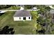Aerial view showcasing the backyard with a sliding glass door, a small patio, and green grass at 6422 Towhlen Rd, North Port, FL 34291