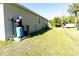 Side yard view with well, water softener and open green lawn at 6422 Towhlen Rd, North Port, FL 34291