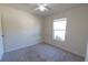 Cozy bedroom with plush carpet, ceiling fan, and natural light from a large window at 6422 Towhlen Rd, North Port, FL 34291