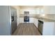 Modern kitchen with stainless steel appliances, granite countertops, and wood-look flooring at 6422 Towhlen Rd, North Port, FL 34291