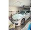 Garage interior featuring a white car, overhead storage, and a neutral color scheme at 6424 Thicket Trl, New Port Richey, FL 34653