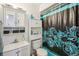 The bathroom features a shower with a blue patterned curtain and a vanity at 7210 N Manhattan Ave # 1721, Tampa, FL 33614