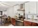 A kitchen with stainless steel hood, granite counters, and dining table in the background at 7210 N Manhattan Ave # 1721, Tampa, FL 33614