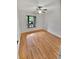 Bright bedroom with wood floors, ceiling fan, and window looking out at 7741 Forest Trl # 7, Port Richey, FL 34668