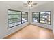 Bright bedroom with wood floors, ceiling fan, and two large windows at 7741 Forest Trl # 7, Port Richey, FL 34668