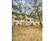 Back of a three-story tan apartment building with sliding glass doors and lawn at 7741 Forest Trl # 7, Port Richey, FL 34668