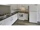 Well-lit kitchen featuring white cabinets, updated hardware, and stainless steel appliances at 7741 Forest Trl # 7, Port Richey, FL 34668