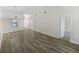 An open concept living room with wood floors and access to other rooms at 7741 Forest Trl # 7, Port Richey, FL 34668