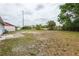 Spacious backyard with a partial brick patio, chain link fence, and potential for landscaping at 7934 Aden Loop, New Port Richey, FL 34655
