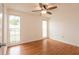 Sunlit bedroom with wood floors, ceiling fan, and two windows at 7934 Aden Loop, New Port Richey, FL 34655
