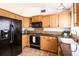 Well-lit kitchen featuring light oak cabinetry and modern black appliances at 7934 Aden Loop, New Port Richey, FL 34655