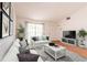 Stylized living room with white sofa set, contemporary furniture and decor and hardwood floors at 7934 Aden Loop, New Port Richey, FL 34655