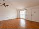 Bright living room with hardwood floors, white walls, a ceiling fan, and large windows offering natural light at 7934 Aden Loop, New Port Richey, FL 34655
