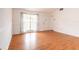 Bright living room with hardwood floors, white walls, and large windows offering natural light at 7934 Aden Loop, New Port Richey, FL 34655