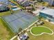 Aerial view featuring tennis courts, putting green, pool, and waterfront access in a vibrant community at 8150 Brent St # 725, Port Richey, FL 34668