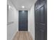 Clean hallway features a closet, light wood floors, and a gray painted entry door at 8150 Brent St # 725, Port Richey, FL 34668