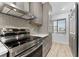 This kitchen features stainless steel appliances, gray cabinets, marble counters, and a window at 8150 Brent St # 725, Port Richey, FL 34668