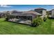 Inviting screened-in pool and spa area with palm trees and well-maintained green grass at 9133 Warm Springs Cir, Parrish, FL 34219