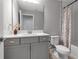 Gray bathroom featuring marble countertop vanity, silver fixtures, and a shower with floral curtain at 9133 Warm Springs Cir, Parrish, FL 34219