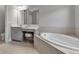 Bright bathroom with a soaking tub, tiled walls, and vanity with seating at 9133 Warm Springs Cir, Parrish, FL 34219