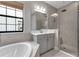 Modern bathroom featuring a soaking tub, walk-in shower and gray vanity at 9133 Warm Springs Cir, Parrish, FL 34219