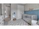 Stylish Bedroom featuring a modern crib, decorative wall accents, and plush checkered rug at 9133 Warm Springs Cir, Parrish, FL 34219