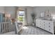 Bright Bedroom showcasing a comfortable chair near a window and a white changing table at 9133 Warm Springs Cir, Parrish, FL 34219