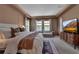 Large bedroom with TV, tray ceiling, decorative rug and furniture at 9133 Warm Springs Cir, Parrish, FL 34219