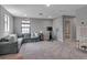 Open bonus room with a gray sectional sofa, TV, seating and access to the bathroom at 9133 Warm Springs Cir, Parrish, FL 34219