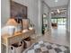 Bright entryway with a stylish console table, artwork, and a view towards the living area and pool at 9133 Warm Springs Cir, Parrish, FL 34219