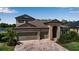Traditional home boasting a brick driveway and a well-maintained, landscaped front yard at 9133 Warm Springs Cir, Parrish, FL 34219