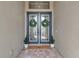 Elegant double front doors with glass panels, wreaths, and a welcoming 'happy place' mat at 9133 Warm Springs Cir, Parrish, FL 34219