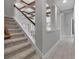 View of stairway featuring carpeted steps, white railings, and an open hallway with wood-look flooring at 9133 Warm Springs Cir, Parrish, FL 34219