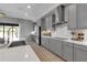 Bright kitchen with gray cabinets, stainless steel appliances, quartz countertops, and an induction cooktop at 9133 Warm Springs Cir, Parrish, FL 34219