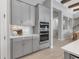 Close up of kitchen's cabinetry with stainless steel appliances and view of a staircase and dining area at 9133 Warm Springs Cir, Parrish, FL 34219