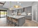 Bright kitchen with gray cabinets, large island with seating and modern pendant lighting at 9133 Warm Springs Cir, Parrish, FL 34219