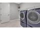 Convenient laundry room with modern washer and dryer units, a utility sink, and ample shelving at 9133 Warm Springs Cir, Parrish, FL 34219