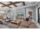 Bright and spacious living room with decorative wood beam ceiling and large sectional sofa at 9133 Warm Springs Cir, Parrish, FL 34219