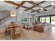 Open-concept living space with dining area, coffered ceiling, and sliding doors to the pool at 9133 Warm Springs Cir, Parrish, FL 34219