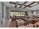 Living room with a cozy sectional sofa, wood beams on the ceiling, and glass doors leading to a pool at 9133 Warm Springs Cir, Parrish, FL 34219