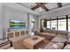 Living room with cozy sectional sofa, wood beams on the ceiling, and glass doors leading to outdoor space at 9133 Warm Springs Cir, Parrish, FL 34219