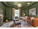 Stylish office space with green walls, a leather couch, decorative chandelier, and a light-filled window at 9133 Warm Springs Cir, Parrish, FL 34219