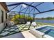 The covered patio boasts a hot tub, egg chair, and artificial grass with views of the lake at 9133 Warm Springs Cir, Parrish, FL 34219