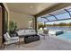 Inviting patio with stylish seating, offering a tranquil view of the pool and lake at 9133 Warm Springs Cir, Parrish, FL 34219