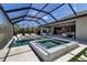 The covered patio has a hot tub, lounge chairs in the water, and artificial grass accents at 9133 Warm Springs Cir, Parrish, FL 34219