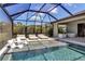 The covered patio features a large pool, hot tub, lounge chairs, and views of the lake at 9133 Warm Springs Cir, Parrish, FL 34219